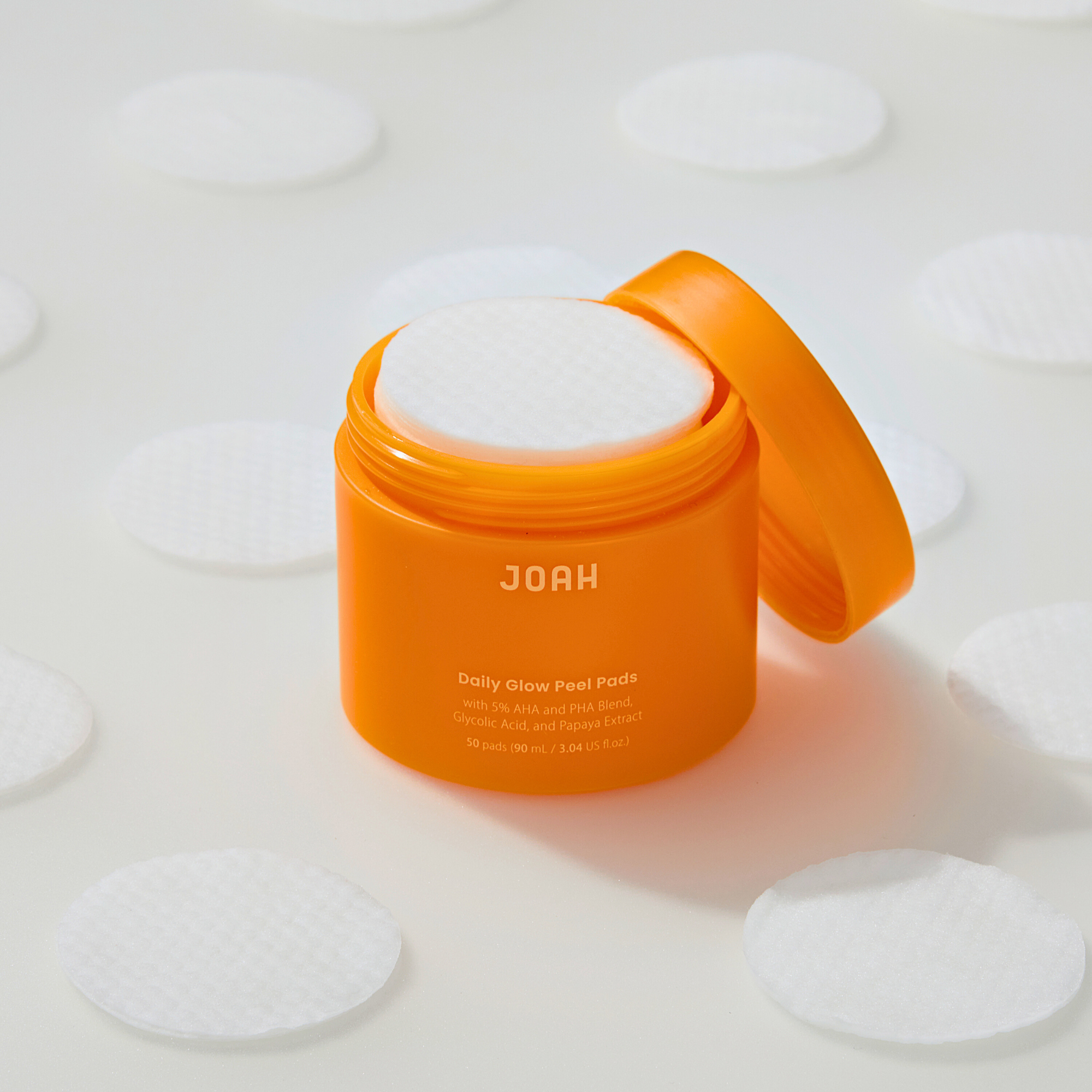 Orange container of JOAH product with white pads on a light background