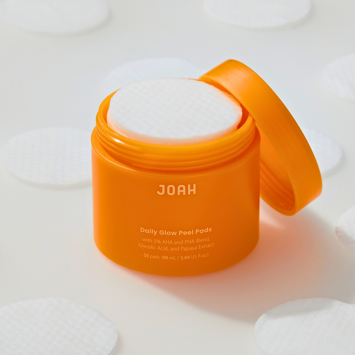 Orange container of JOAH product with white pads on a light background