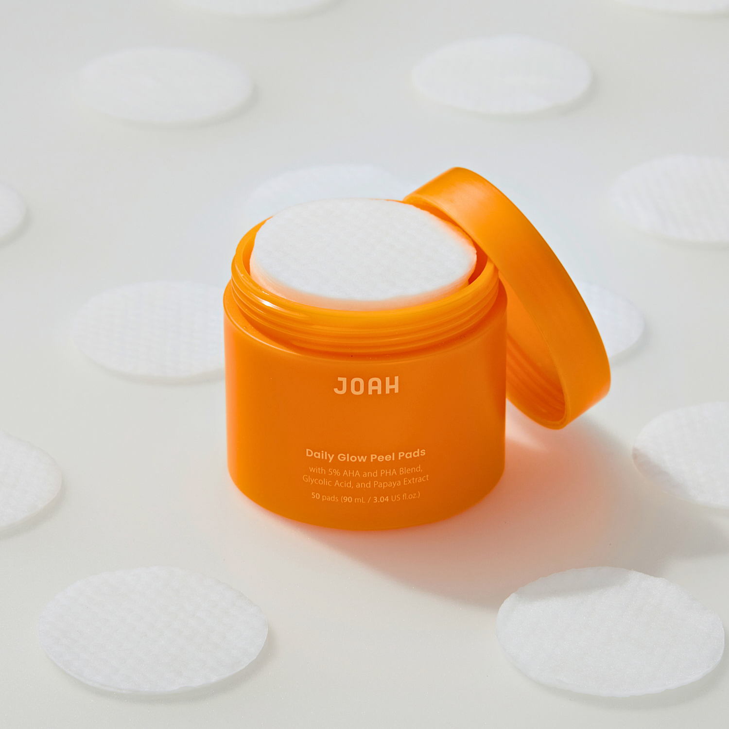 Orange container of JOAH product with white pads on a light background